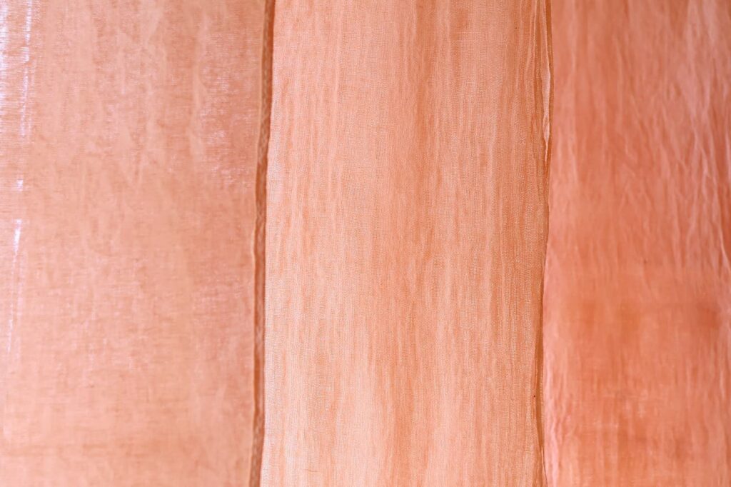 桜の枝でピンク色に染まった布