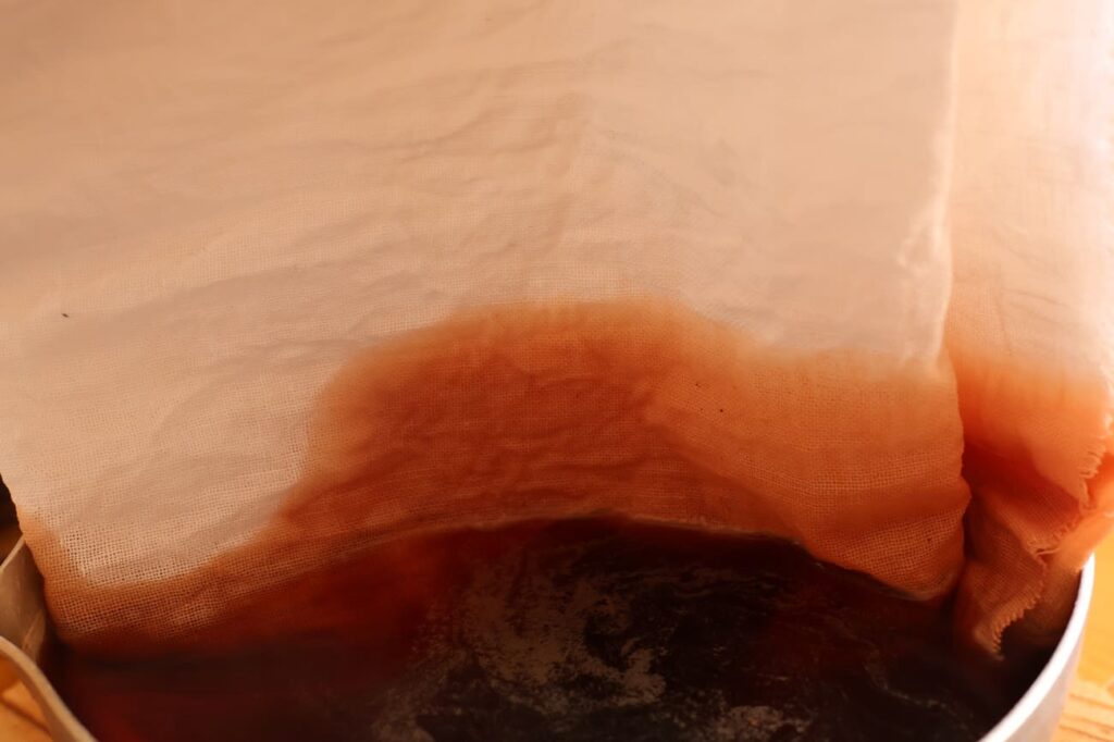 桜の剪定枝で作った染液に布を浸ける